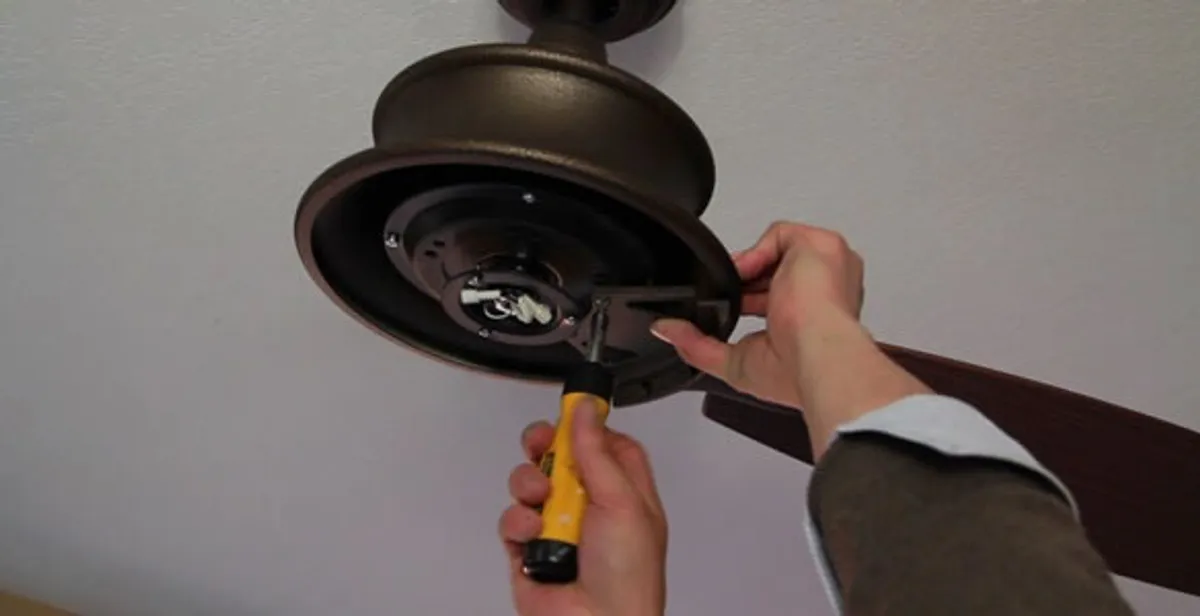 Electrician installing ceiling fan mounting bracket and fixture in St Paul, MN