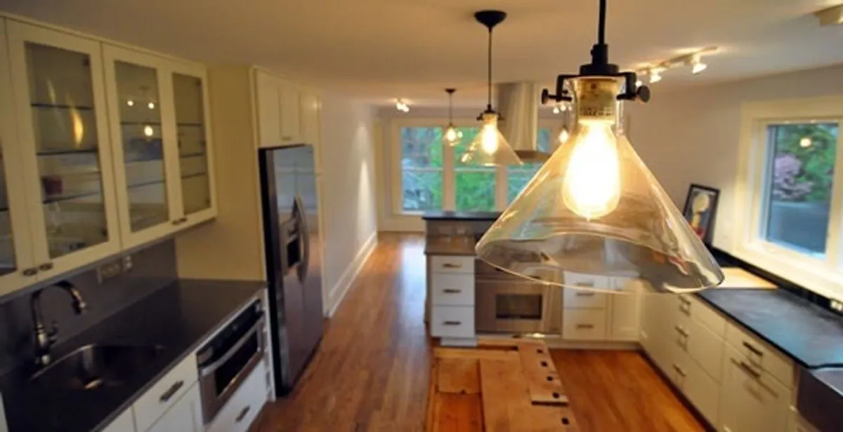 Residential electrician installing modern indoor light fixture in a home in St Paul, MN